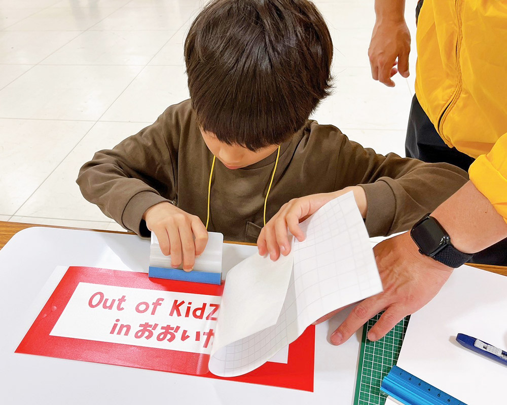 カッティングシートを貼り付ける子ども