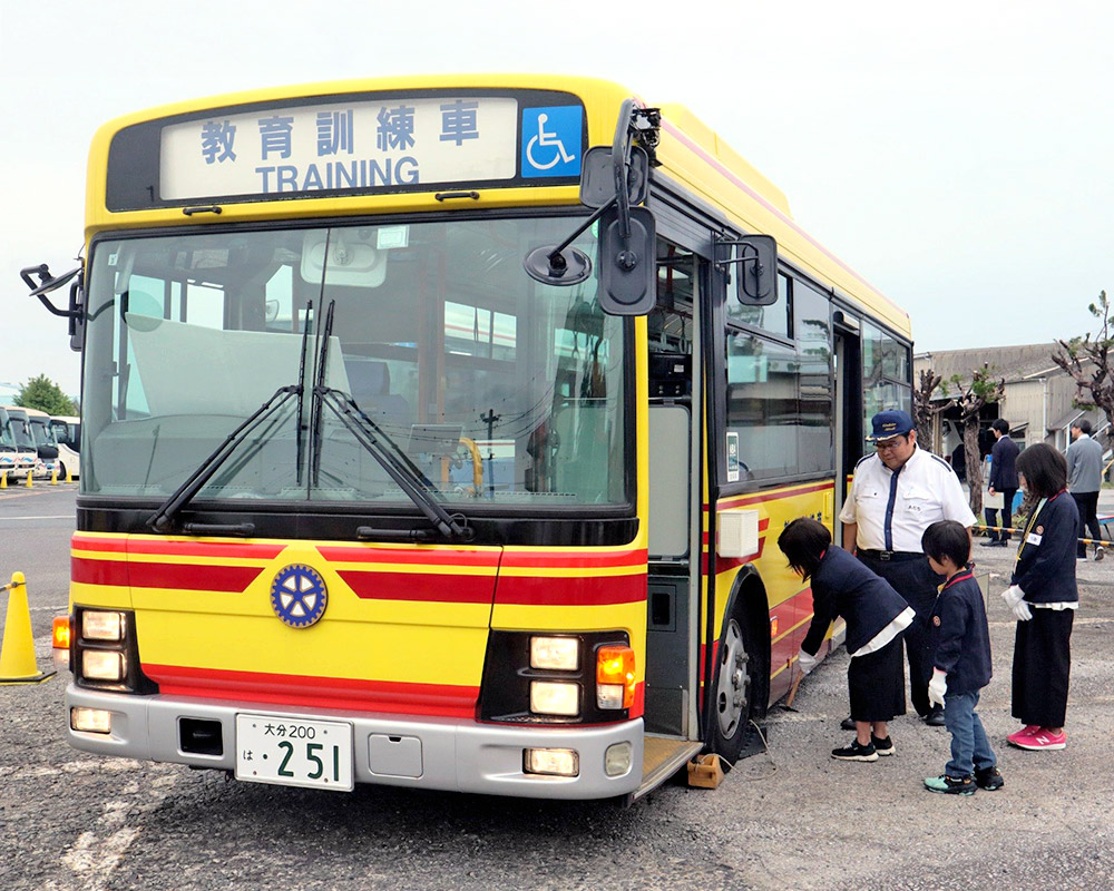 バスの横に立つ運転士と子どもたち