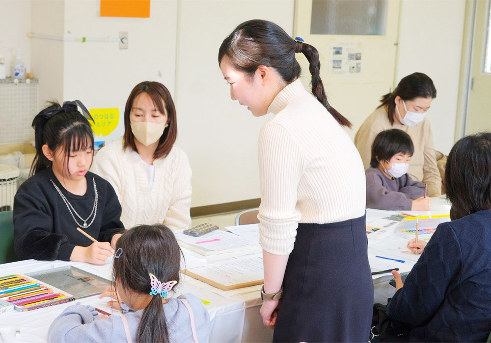 色鉛筆を持って紙に向かう子どもたち