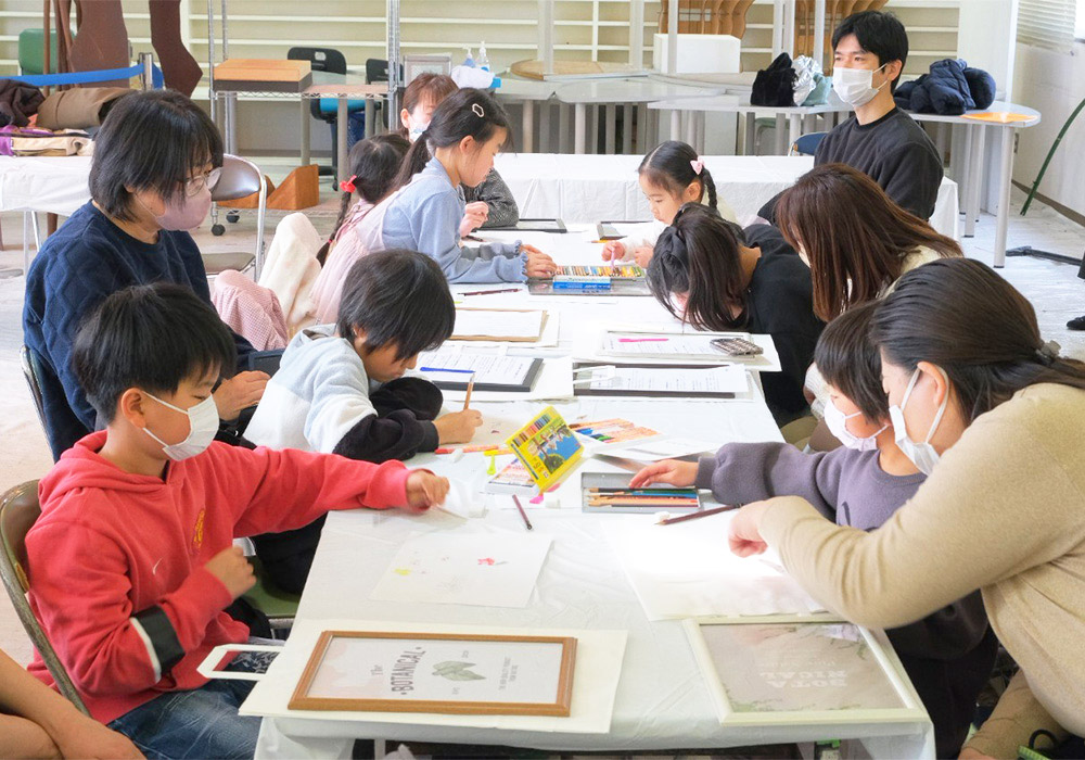 色鉛筆を持って紙に向かう子どもたち