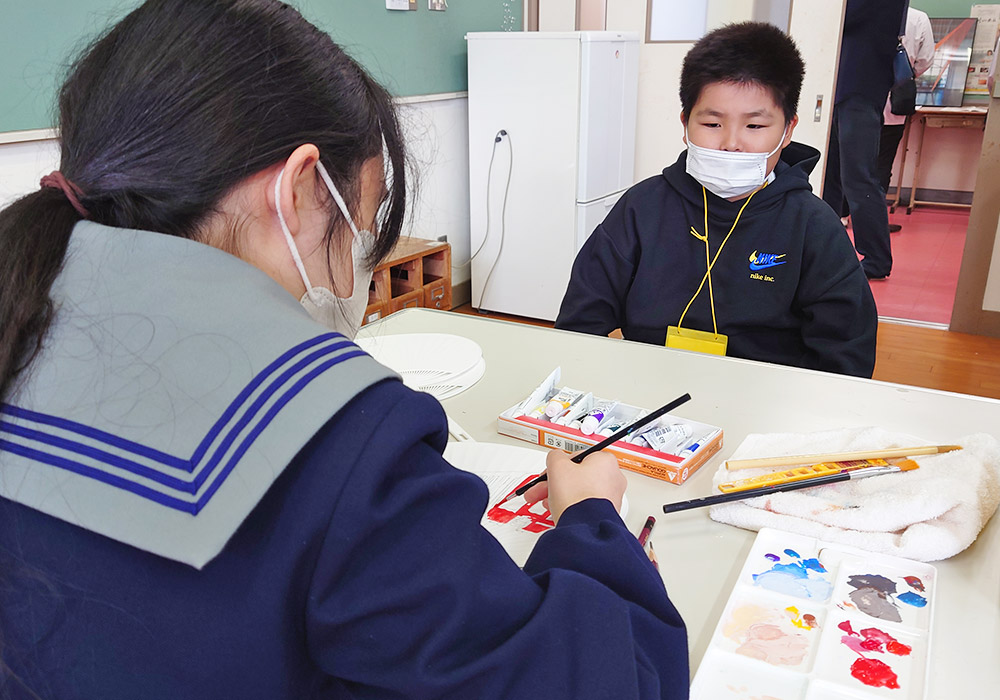 絵を描く様子を眺める男の子