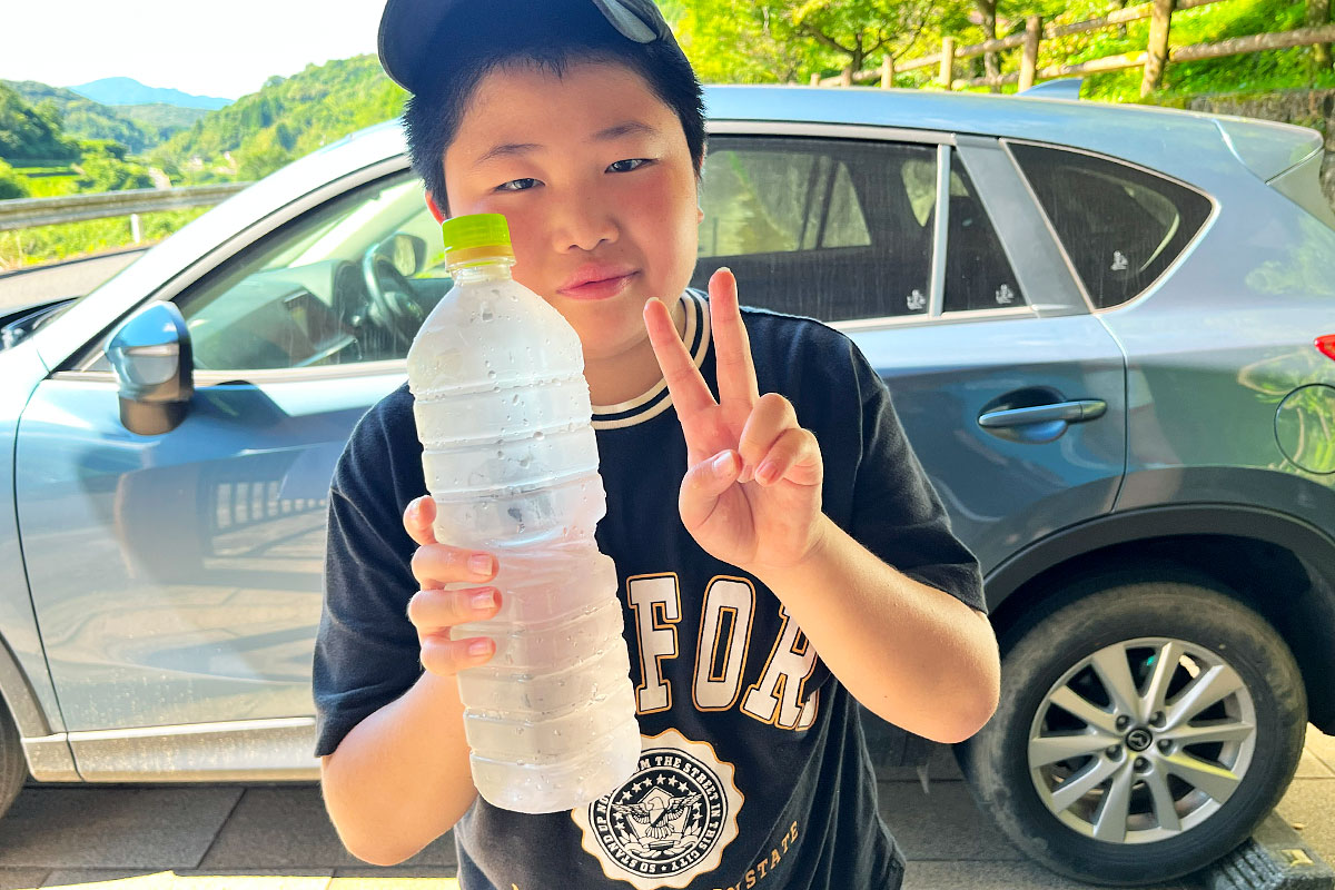 水を汲んでピースサイン