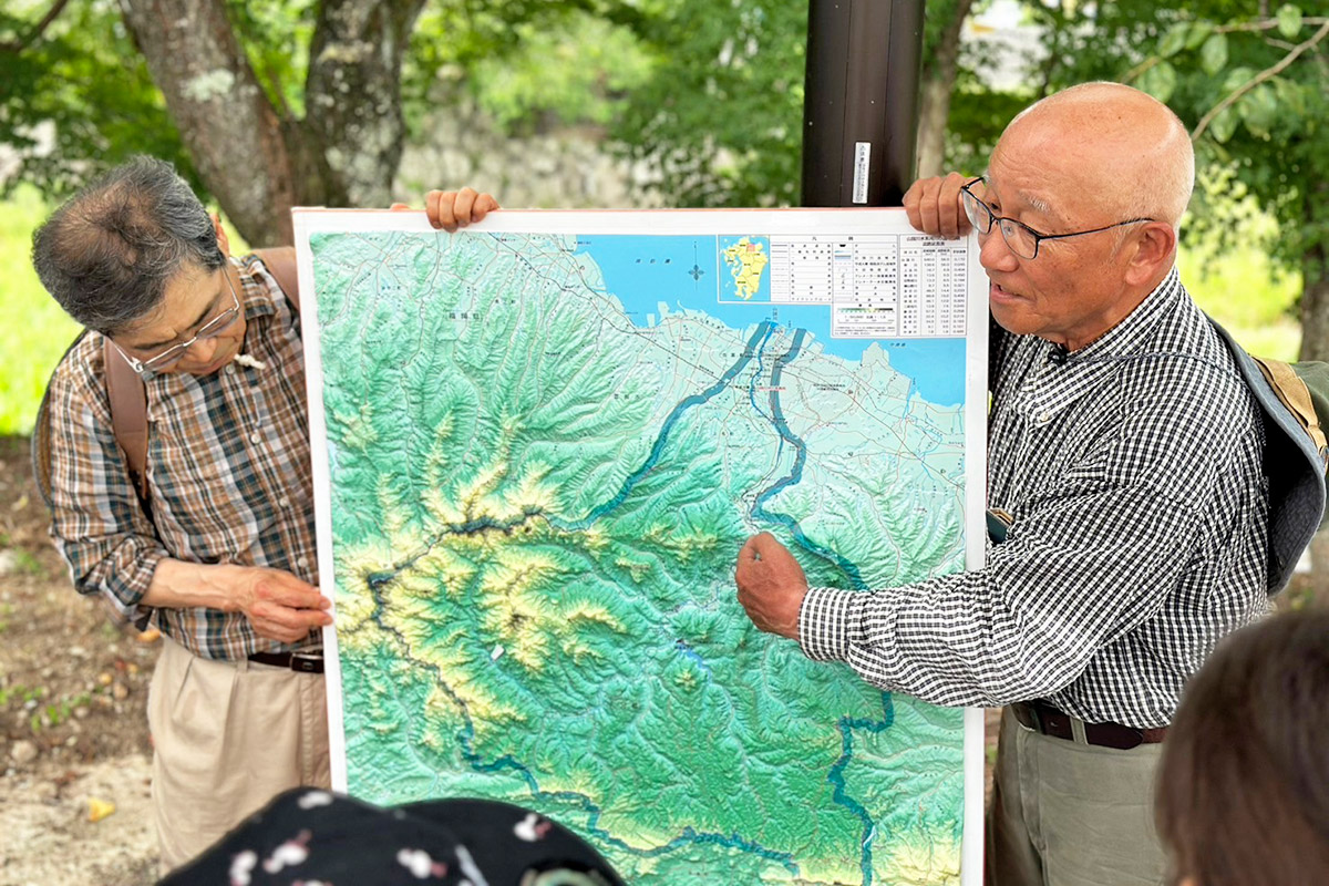 地図を広げて説明する先生