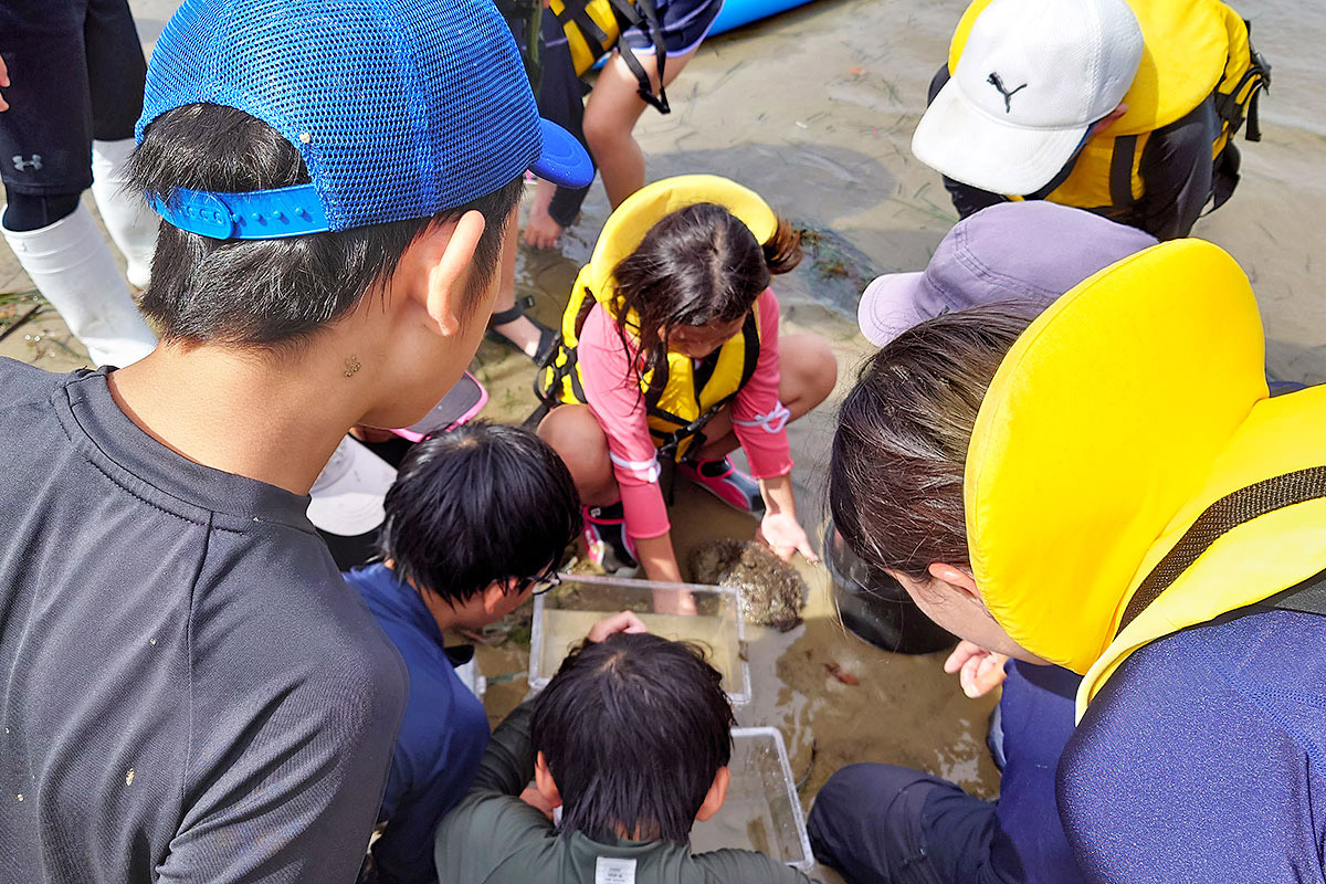 魚を捕まえてピースサイン