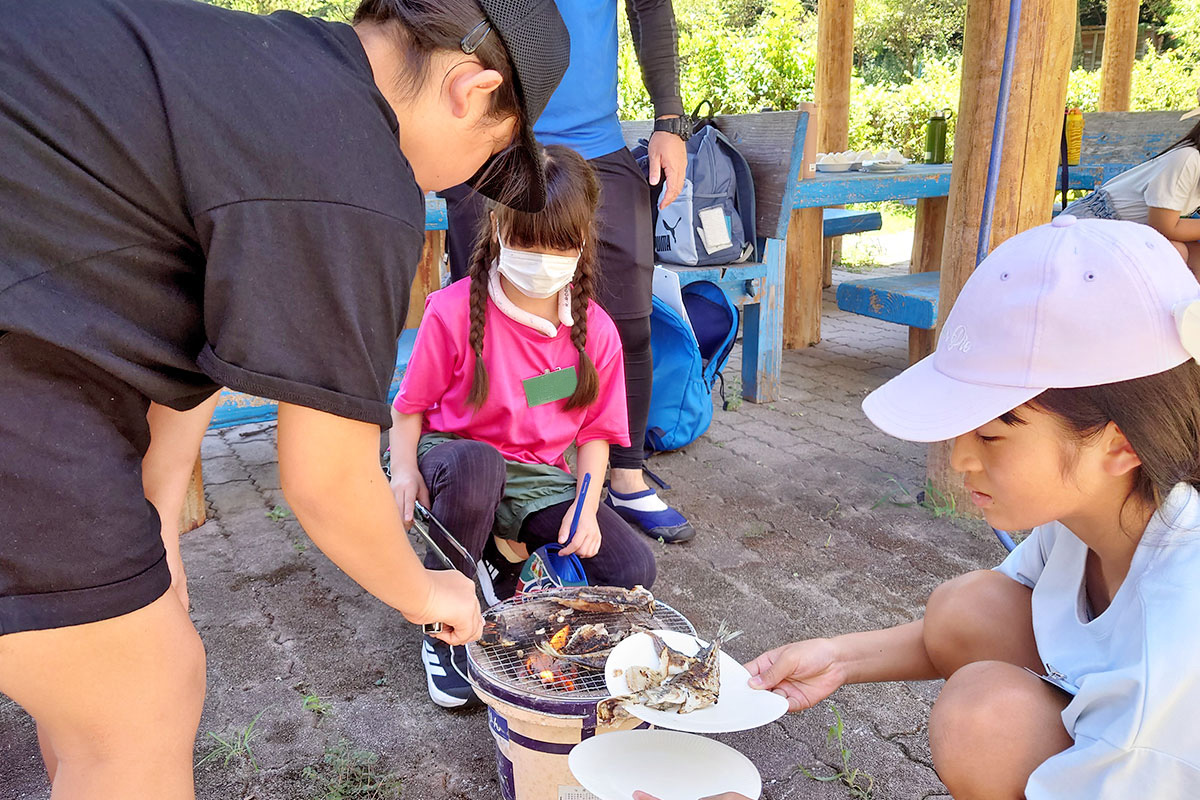 七輪で魚を焼く子どもたち